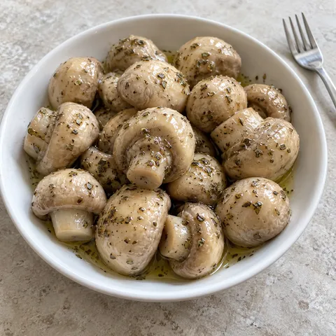 Champignon sott’olio con origano e pepe in una ciotola bianca