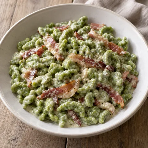 Spätzle verdi agli spinaci con panna cremosa e listarelle di speck rosolato